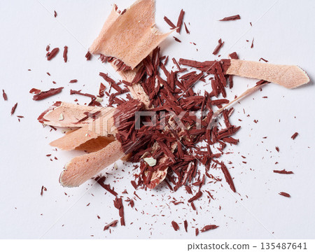 Wooden brown shavings of lead pencil on white background, top view Wooden brown shavings of lead pencil on white background, top view 135487641