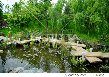 Wooden zigzag Japanese bridge in   Japanese garden in Krasnodar 135488848