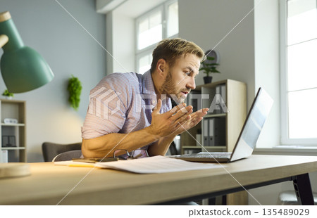 Angry businessman looking at laptop screen in anger during technical issue 135489029