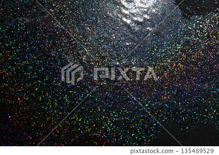 Festive black and silver holographic glitter texture with rainbow highlights. Festive black and silver holographic glitter texture with rainbow highlights. 135489529