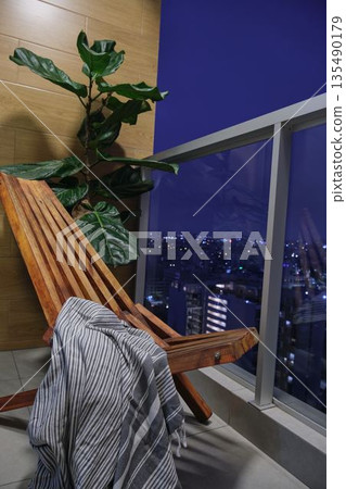 Balcony relaxation with city night view and lounge chair 135490179