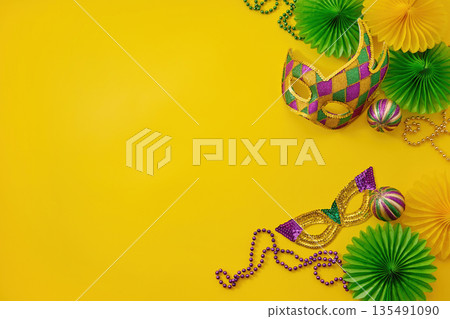 Mardi gras carnival masks beads yellow background with copy space 135491090