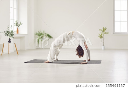 Yogi beautiful young woman working out in fitness club, home, doing yoga pilates exercise Yogi beautiful young woman working out in fitness club, home, doing yoga pilates exercise 135491137