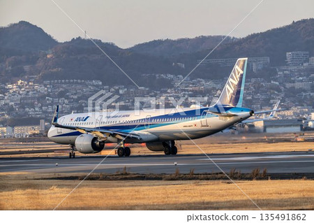 Osaka Airport (Itami Airport) in the evening. Taxiing plane. Toyonaka City, Osaka Prefecture. Osaka Airport (Itami Airport) in the evening. Taxiing plane. Toyonaka City, Osaka Prefecture. 135491862