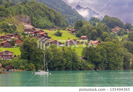Hillside houses above Lake Brienz in Iseltwald Switzerland 135494365
