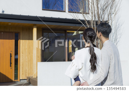 Family standing in front of the house Family standing in front of the house 135494583