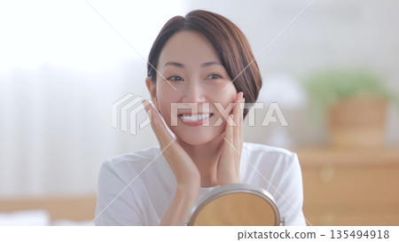 看鏡子和微笑的婦女 看鏡子和微笑的婦女 135494918