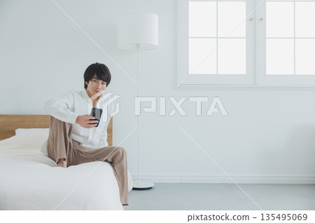 Men watching smartphones in bed 135495069