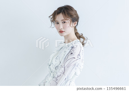 一位身穿洋裝的年輕女子站在白色背景上 一位身穿洋裝的年輕女子站在白色背景上 135496661