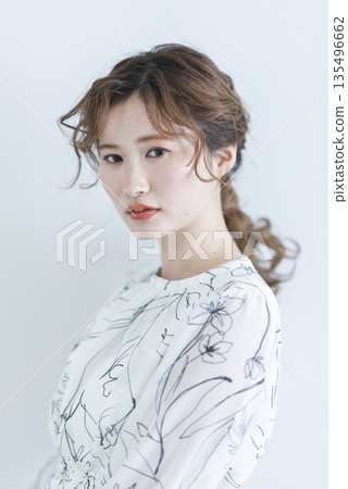 一位身穿洋裝的年輕女子站在白色背景上 一位身穿洋裝的年輕女子站在白色背景上 135496662