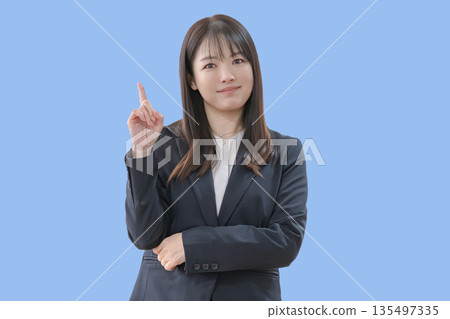 藍色背景,一位女商人正指著前方。 藍色背景,一位女商人正指著前方。 135497335