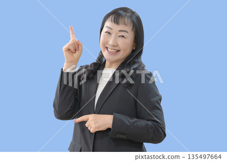 Blue background and pointing businesswoman 135497664