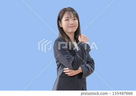 一位女子緊握拳頭，背景是藍色。 135497666