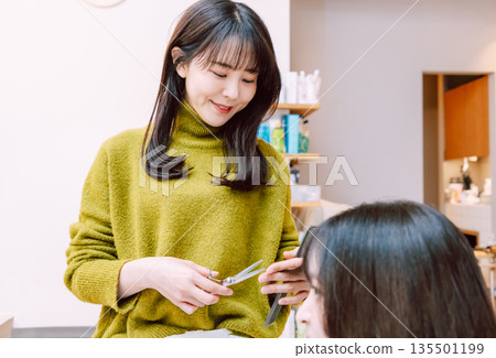 Female hairdresser cutting hair at beauty salon Female hairdresser cutting hair at beauty salon 135501199