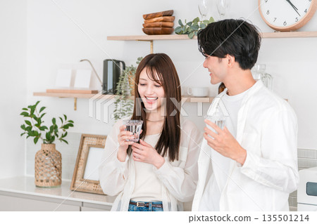 一對年輕的亞洲夫婦在廚房喝水 135501214
