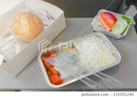 Lunch on the plane - rice, fresh fish and salad with a bun. High quality photo Lunch on the plane - rice, fresh fish and salad with a bun. High quality photo 135501240