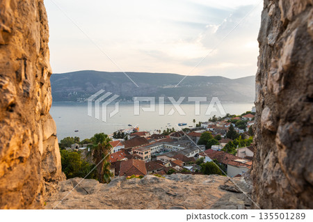A sunlit panorama of a seaside town framed by ancient stone walls of Herceg Novi 135501289