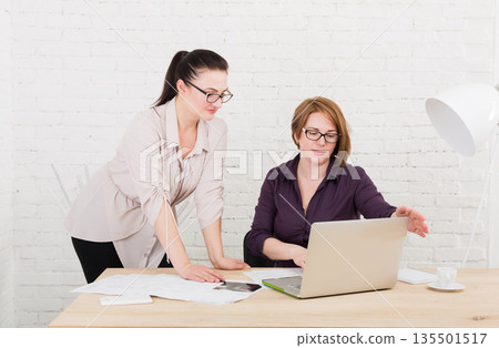 Two women in the office. Teamwork, business communication. Middle-aged architects designers in team work discuss project. Start up discussion. Female coworkers. 135501517