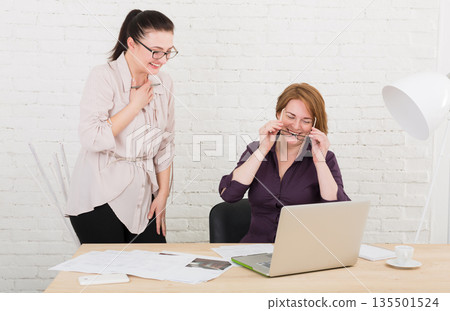 Women have fun in office. Teamwork, friendly business communication. Middle-aged architects designers discuss project. Female coworkers. Women have fun in office. Teamwork, friendly business communication. Middle-aged architects designers discuss project. Female coworkers. 135501524