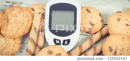 Glucose meter for checking sugar level and cookies Glucose meter for checking sugar level and cookies 135501587