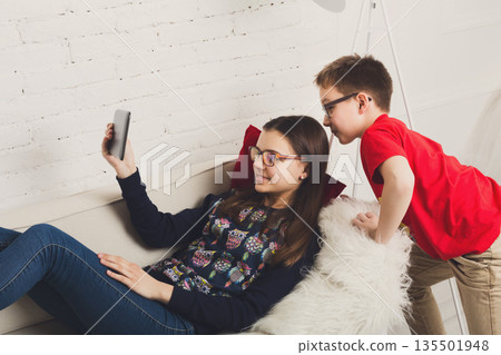 Group of kids in eye glasses look into tablet. Children computer games, social networks and media addiction concept. Girl and boys with gadget. Communication technologies. 135501948