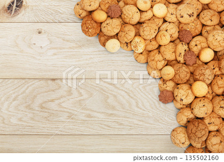 Cookies and sweet biscuits at natural wood, background with copy space. Oatmeal and chocolate drops cookies border, dessert for tea. Cookies and sweet biscuits at natural wood, background with copy space. Oatmeal and chocolate drops cookies border, dessert for tea. 135502160
