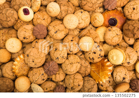 Cookies background. Sweet chocolate chips biscuits, shortbread with jam texture background. Oatmeal, chocolated drops and other sweets. 135502275