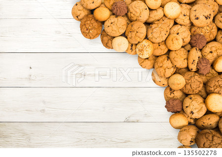 Cookies and biscuits sweets on white wood, background with copy space. Oatmeal and chocolate drops pastry border, dessert for tea. Cookies and biscuits sweets on white wood, background with copy space. Oatmeal and chocolate drops pastry border, dessert for tea. 135502278