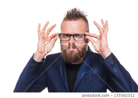 Young bearded man isolated at white background. Portrait of a confident stylish guy in eyeglasses looking at camera. Boy style, trendy hipster with cool hairstyle in blue suit. Young bearded man isolated at white background. Portrait of a confident stylish guy in eyeglasses looking at camera. Boy style, trendy hipster with cool hairstyle in blue suit. 135502312