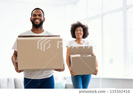 New Home. African American Couple Moving Carrying Cardboard Boxes Entering Own Apartment After Relocation. Real Estate Concept. Young Family Housing, Property Ownership And Purchase New Home. African American Couple Moving Carrying Cardboard Boxes Entering Own Apartment After Relocation. Real Estate Concept. Young Family Housing, Property Ownership And Purchase 135502458