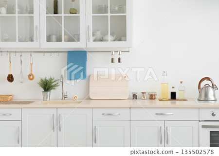 Apartment rental, new minimal, scandinavian design after renovation and modern style, flat or house for sale. White furniture with utensils, light wall in simple interior at morning, empty space Apartment rental, new minimal, scandinavian design after renovation and modern style, flat or house for sale. White furniture with utensils, light wall in simple interior at morning, empty space 135502578