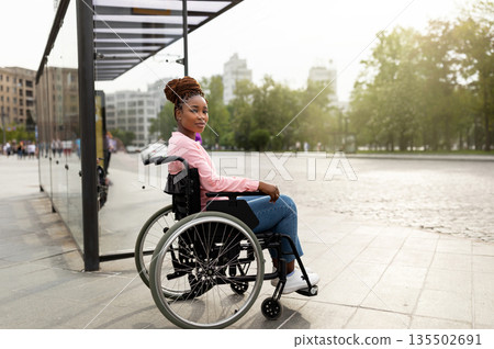 Problem of public transport for people with disabilities. Young black handicapped woman in wheelchair feeling stressed, cannot board vehicle suitable for impaired persons, waiting on bus stop Problem of public transport for people with disabilities. Young black handicapped woman in wheelchair feeling stressed, cannot board vehicle suitable for impaired persons, waiting on bus stop 135502691