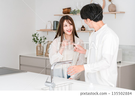 Smiling couple drinking water in the kitchen, husband and wife (water purifier, tap water) Smiling couple drinking water in the kitchen, husband and wife (water purifier, tap water) 135502884