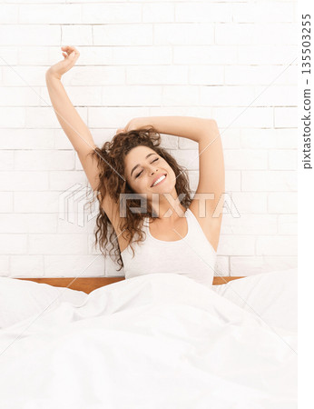 Comfortable mattress. Happy rested woman stretching in morning, enjoying her new bed, closeup Comfortable mattress. Happy rested woman stretching in morning, enjoying her new bed, closeup 135503255