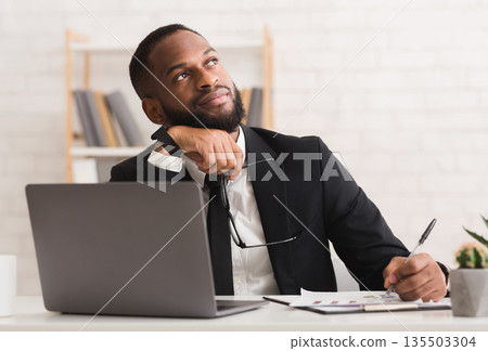 Dreamy afro entrepreneur thinking about his company future, making plans, copy space Dreamy afro entrepreneur thinking about his company future, making plans, copy space 135503304