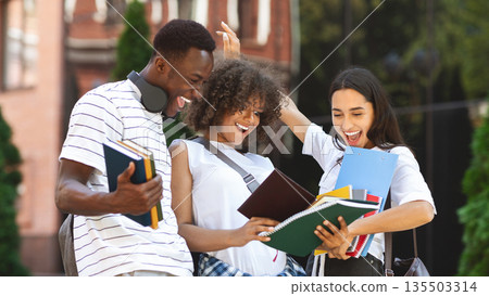 Overjoyed Multicultural Students Checking Exam Results And Celebrating Success, Standing Over University Background, Panorama 135503314