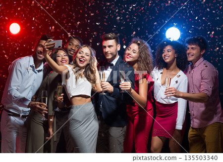 Holiday group selfie. Young friends having fun at New Year's Eve party and taking photo, copy space Holiday group selfie. Young friends having fun at New Year's Eve party and taking photo, copy space 135503340