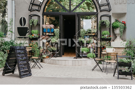Eco cafe on street and flower studio, small business in city, reopening after covid-19, outdoor interior. Sign board with menu, tables for clients, potted plants on shelf at modern store, nobody 135503362