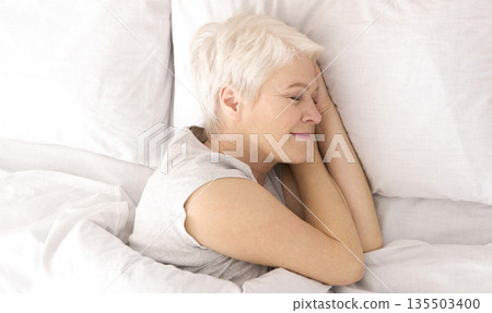 Good sleep. Healthy senior woman napping in bed, top view, panorama 135503400