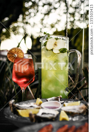 Mixed cocktail drinks and sangria with snacks on restaurant table outdoors at sunset Mixed cocktail drinks and sangria with snacks on restaurant table outdoors at sunset 135503415