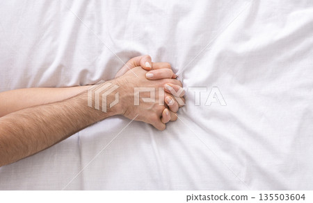 Make love. Young male and female hands on bed, closeup, empty space 135503604