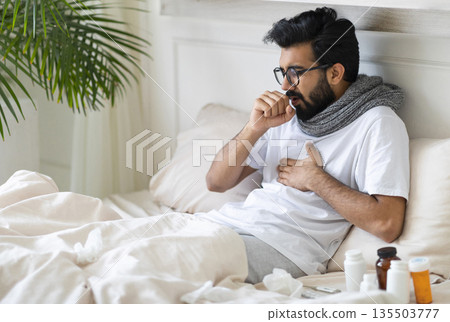 Sick Young Indian Man Coughing While Sitting In Bed At Home, Ill Millennial Eastern Guy Resting In Bedroom, Suffering Bronchitis, Having Seasonal Flu Or Cold Symptoms, Closeup With Free Space Sick Young Indian Man Coughing While Sitting In Bed At Home, Ill Millennial Eastern Guy Resting In Bedroom, Suffering Bronchitis, Having Seasonal Flu Or Cold Symptoms, Closeup With Free Space 135503777