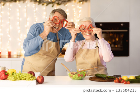 Joyful Senior Couple Having Fun Posing With Vegetables Cooking Together In Modern Kitchen At Home. Christmas Dinner Preparation, Holidays Celebration And Xmas Recipes Concept Joyful Senior Couple Having Fun Posing With Vegetables Cooking Together In Modern Kitchen At Home. Christmas Dinner Preparation, Holidays Celebration And Xmas Recipes Concept 135504213