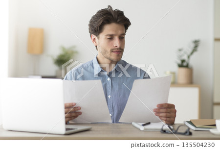 Serious Business Man Working With Papers Sitting At Laptop In Modern Office. Selective Focus 135504230