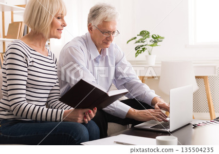 Mature Couple Checking Domestic Finances And Calculating Bills Using Laptop Mature Couple Checking Domestic Finances And Calculating Bills Using Laptop 135504235