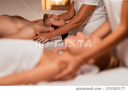 Husband And Wife Relaxing During Massage Session For Two Lying On Beds At Luxury Spa Resort Indoors. Body Relaxation, Wellness And Beauty Treatment, Massaging Therapy. Selective Focus Husband And Wife Relaxing During Massage Session For Two Lying On Beds At Luxury Spa Resort Indoors. Body Relaxation, Wellness And Beauty Treatment, Massaging Therapy. Selective Focus 135505177