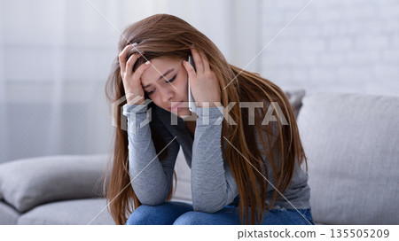 Upset young woman talking to her psychologist on cellphone, receiving help in depression treatment at home. Millennial lady having relationship problems, consulting her therapist on phone 135505209