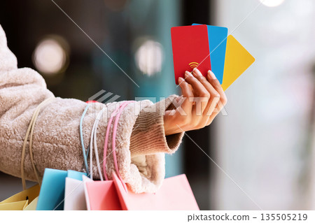 Spending Money, Discount Concept. Closeup Of Unrecognizable African American Woman Holding Three Colorful Credit Cards In Hand, Standing With Shopping Bags Outside Near MalL, Selective Focus Spending Money, Discount Concept. Closeup Of Unrecognizable African American Woman Holding Three Colorful Credit Cards In Hand, Standing With Shopping Bags Outside Near MalL, Selective Focus 135505219