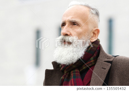 Stylish elderly man in warm outfit going to office, drinking coffee, carrying leather bag, looking aside. Senior grey-haired man walking by street, having coffee to go, business center behind Stylish elderly man in warm outfit going to office, drinking coffee, carrying leather bag, looking aside. Senior grey-haired man walking by street, having coffee to go, business center behind 135505432