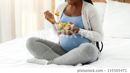 Pregnant Woman Nutrition. Happy Black Expecting Lady Eacting Fresh Vegetable Salad While Sitting In Bed, Smiling African American Female Enjoying Healthy Organic Food During Pregnancy, Copy Space Pregnant Woman Nutrition. Happy Black Expecting Lady Eacting Fresh Vegetable Salad While Sitting In Bed, Smiling African American Female Enjoying Healthy Organic Food During Pregnancy, Copy Space 135505471
